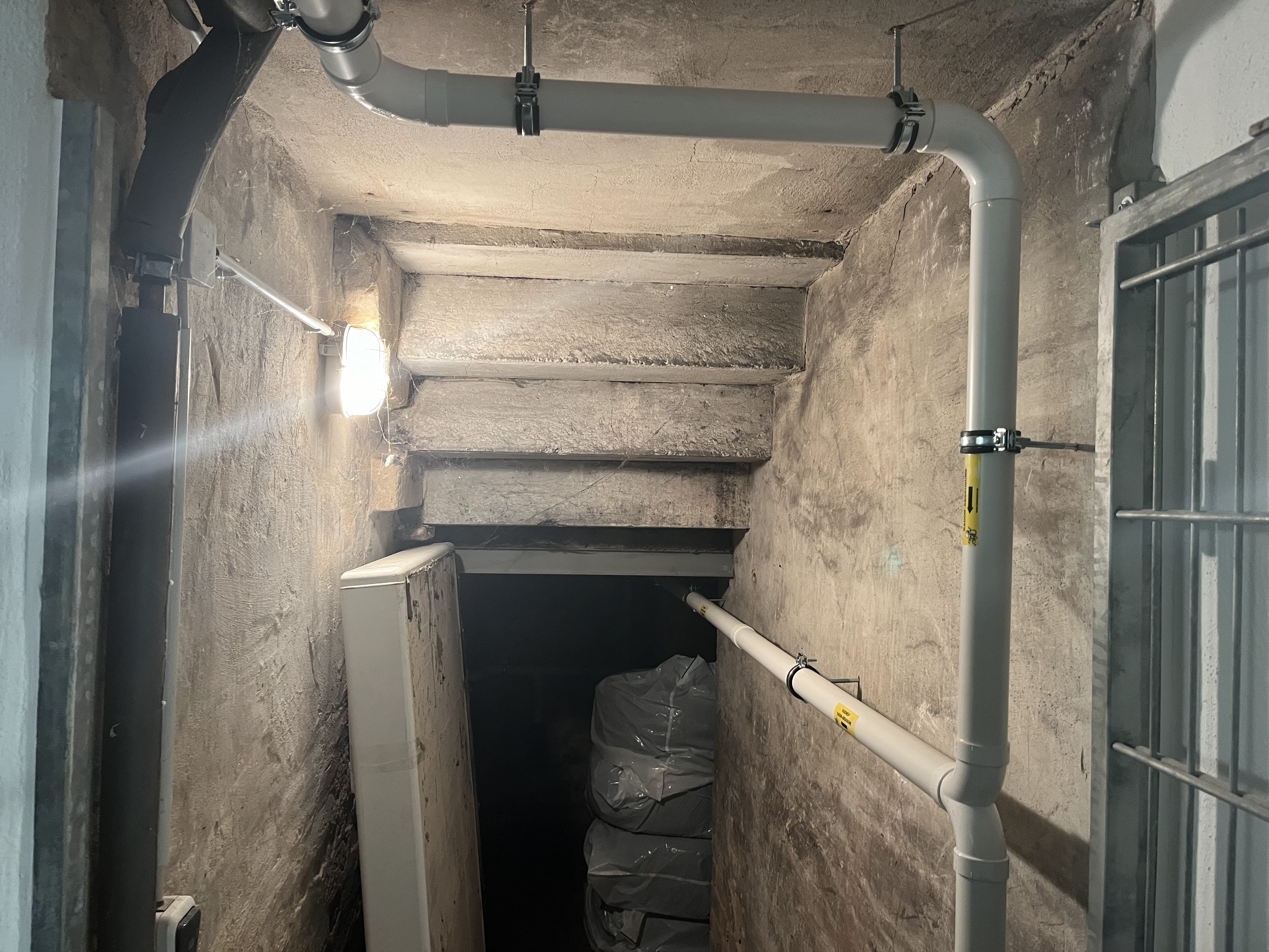 Radon-Unterbodenabsaugung: Leitungsführung im Kellertreppenhaus