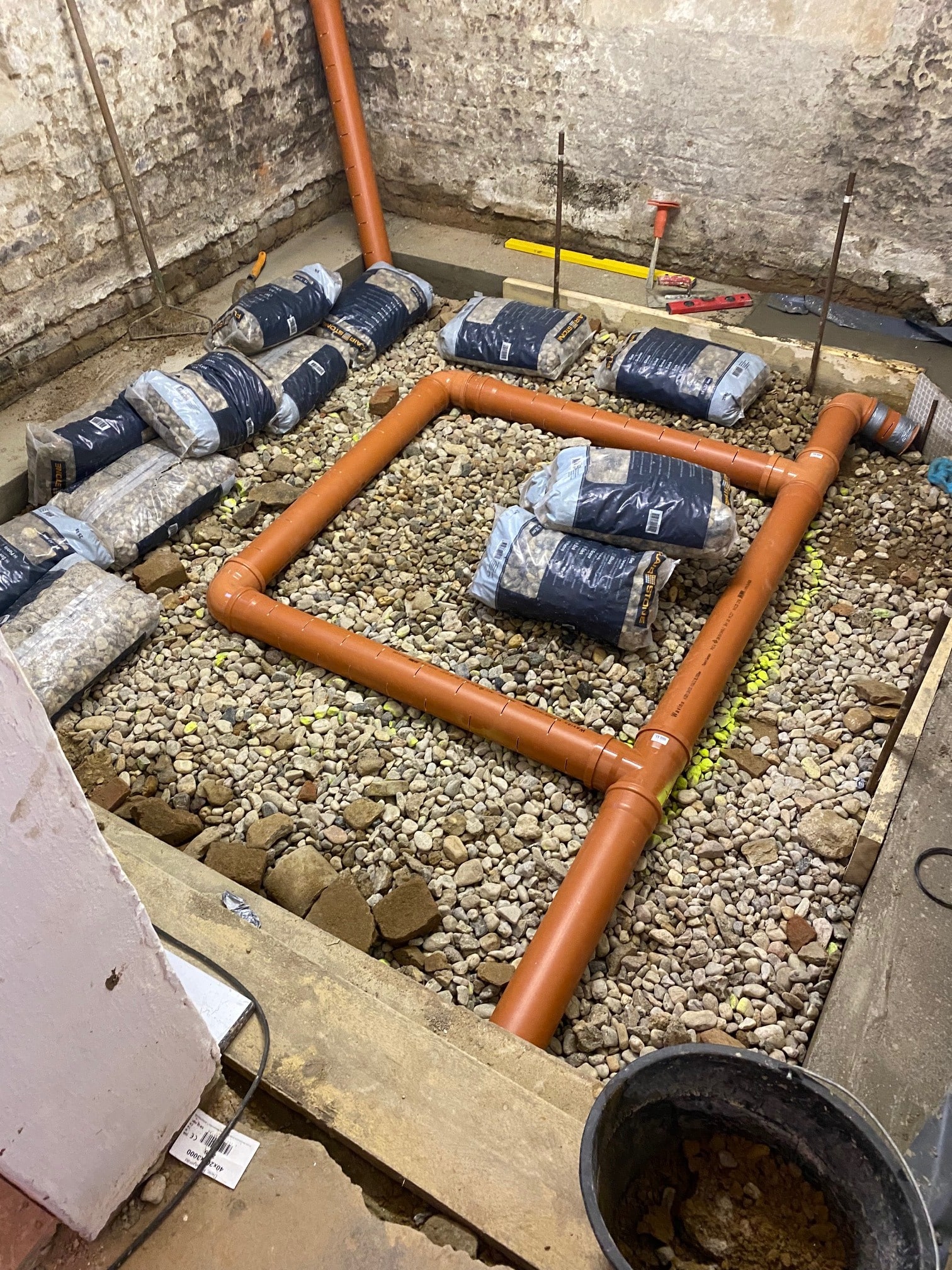 Perforierte Drainagerohre der Radon-Drainage im durchlässigen Kiesbett